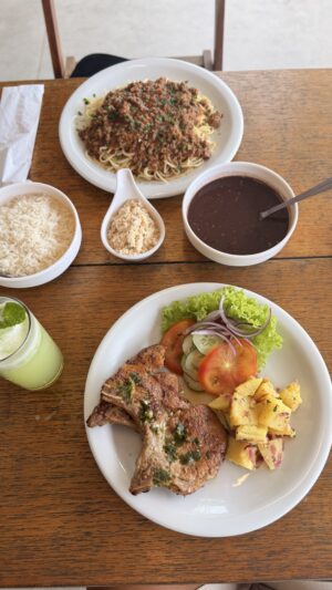 Carré com acompanhamentos separados e macarrão a bolonhesa.